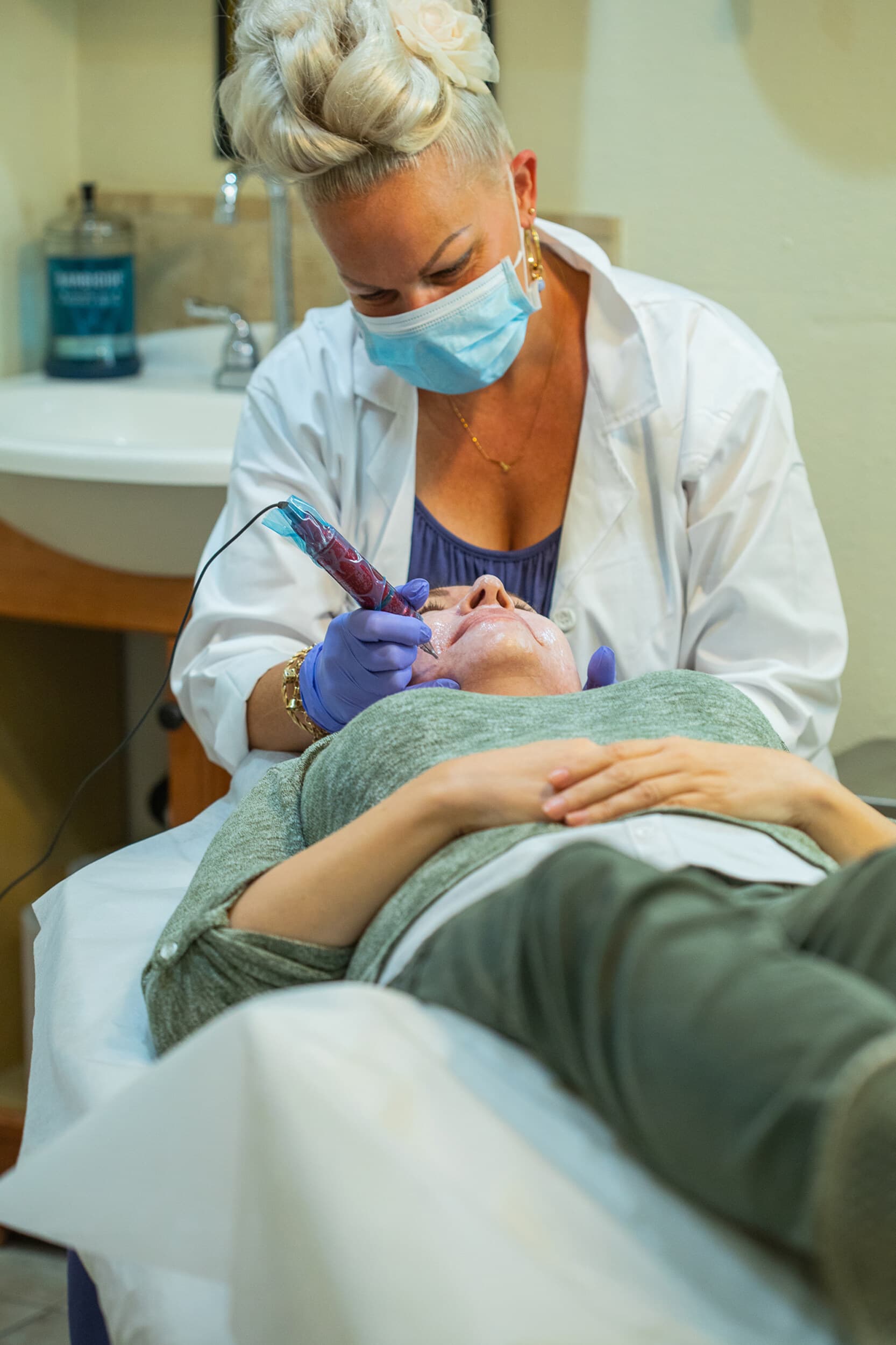 Esthetician in a white coat photographed at work in her own treatment room during an on-location branding session